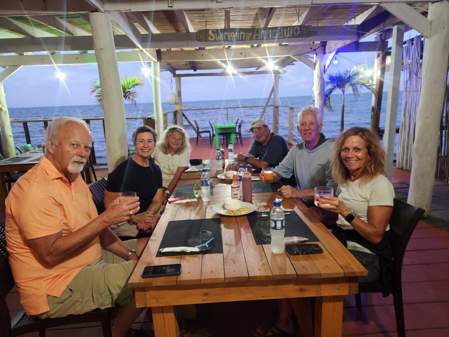 Guests sharing drinks and dinner beside the Caribbean at Swinging Armadillo