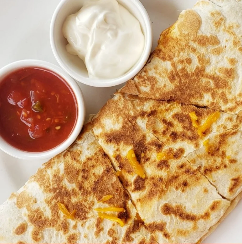 Golden toasted quesadilla wedges with salsa and a creamy dip